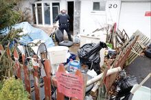 Scott Township Police Sergeant Joseph Grassley, above, shines a flashlight inside 20 Shawnee Road in Scott Township on Thursday. The house was condemned by the borough on Thursday.