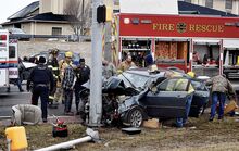 Rescuers, at left, load the driver of a Chrysler 300 into a Bloomsburg ambulance after he drove into a pole along Buckhorn Road on Saturday.