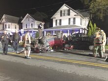 Tow Truck Driver Ryan Lynn balances on top of an overturned Jeep Patriot as he prepares to flip it right side up after an early morning crash in Bloomsburg.