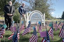 The Rev. William Barbee and retired Navy SEAL Team 6 member Kevin Farrell pose by flags honoring area veterans. Farrell is to be the keynote speaker at a Nov. 11 ceremony. Money raised by the flags will be presented to the new veterans center at McBride Memorial Library.