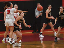 Southern Columbia’s Loren Gehret, second from left, cuts under Mount Carmel’s Jenna Pizzoli while clearing the ball from Pizzoli during the first quarter of Tuesday night’s game at Mount Carmel. Mount Carmel went on to win 41-40.