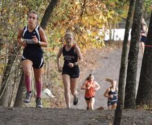 Berwick’s Sophia Tripp, left, leads a group of girls up a hill as they head back out on the course for their second lap during a cross country event incvolving seven school districts at Northwest Area School District.